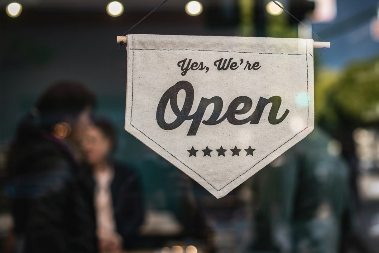 Un letrero de neón que dice OPEN encendido en la ventana de un local